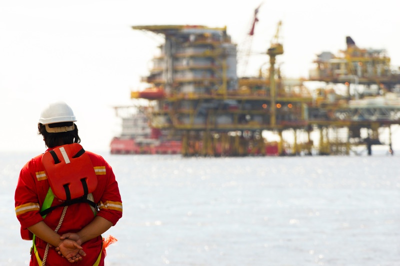 field technician looking at oil rig